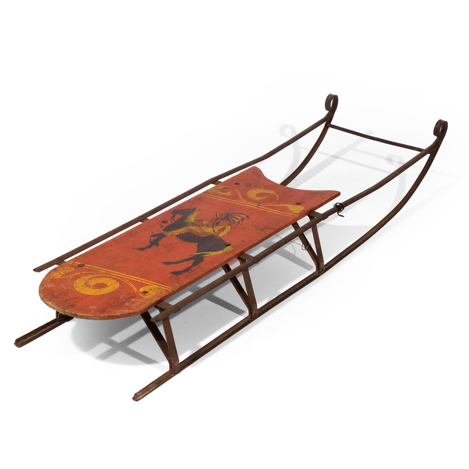 CHILD'S RED PAINT-DECORATED WOOD SLED: Circa 1890, with Native American on horseback h. 5 w. 41-1/2 d. 11 in. Provenance: RJG Antiques, Rye, New Hampshire;The Important American Folk Art Collection of Stephen and Petra Levin, Sotheby's, Ne