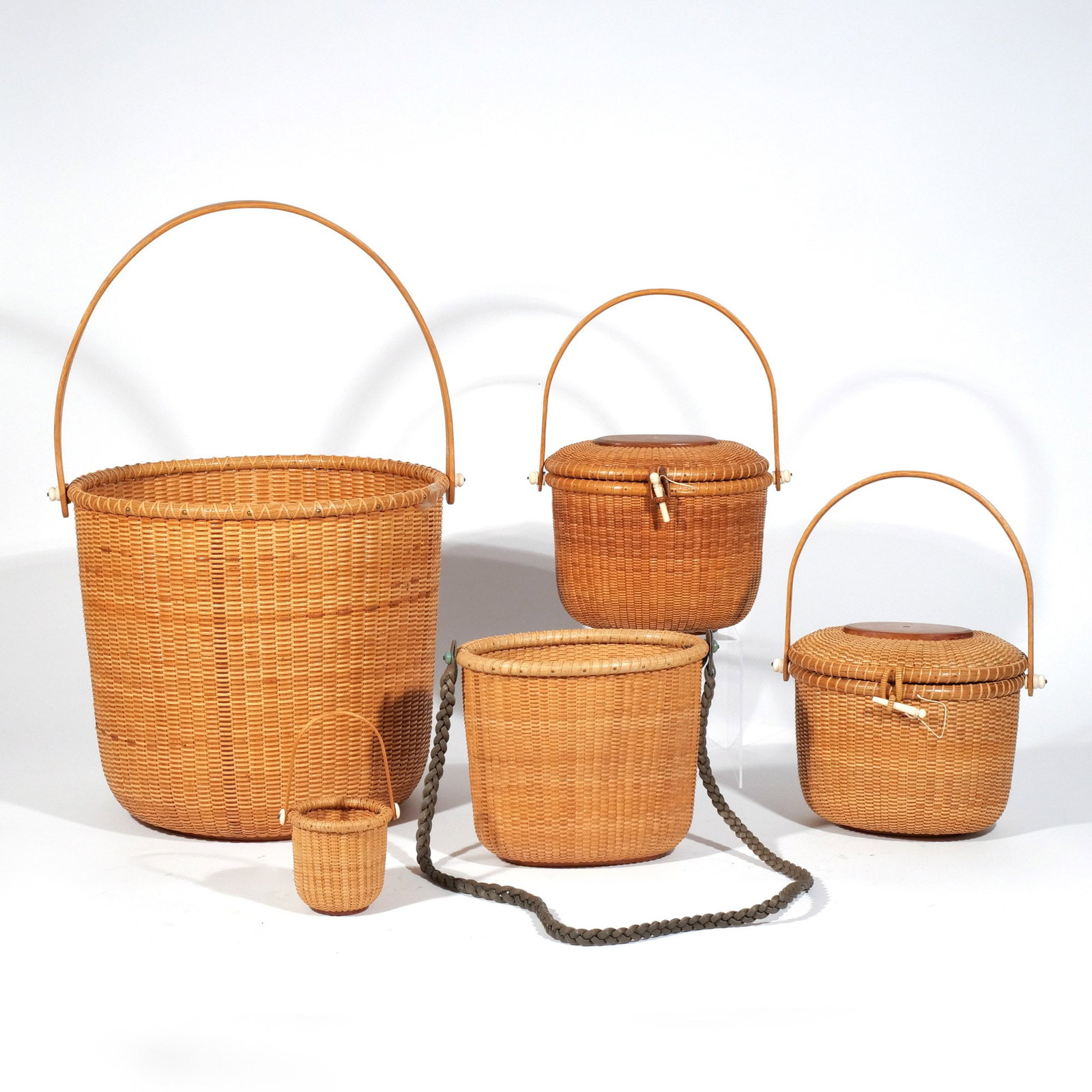 (5pc) NANTUCKET BASKETS: Including a closed-top friendship basket signed 'Jean Bergstresser '97', a similar friendship basket (unsigned), an open top lightship basket engraved 1996 and fashioned as a shoulder bag with