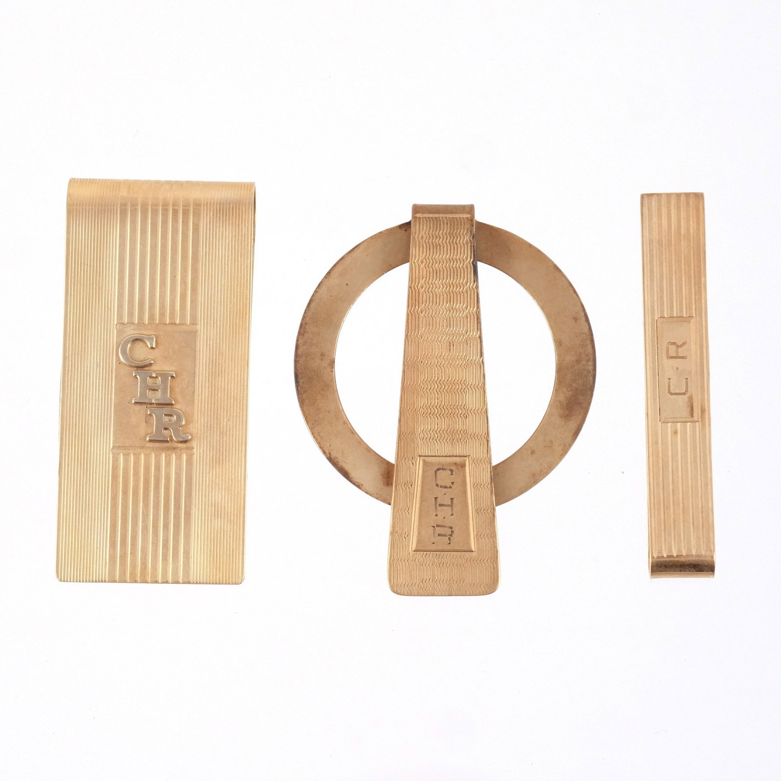 (3pc) 14K GOLD TIE/MONEY CLIPS: Including one wide money clip, one bar clip, and one circular clip, all marked 14k, 41.5 g total weight h. 2-1/4 w. 1 in. (largest) Provenance: The estate of a noted architect and bibliophile, Rye, NY