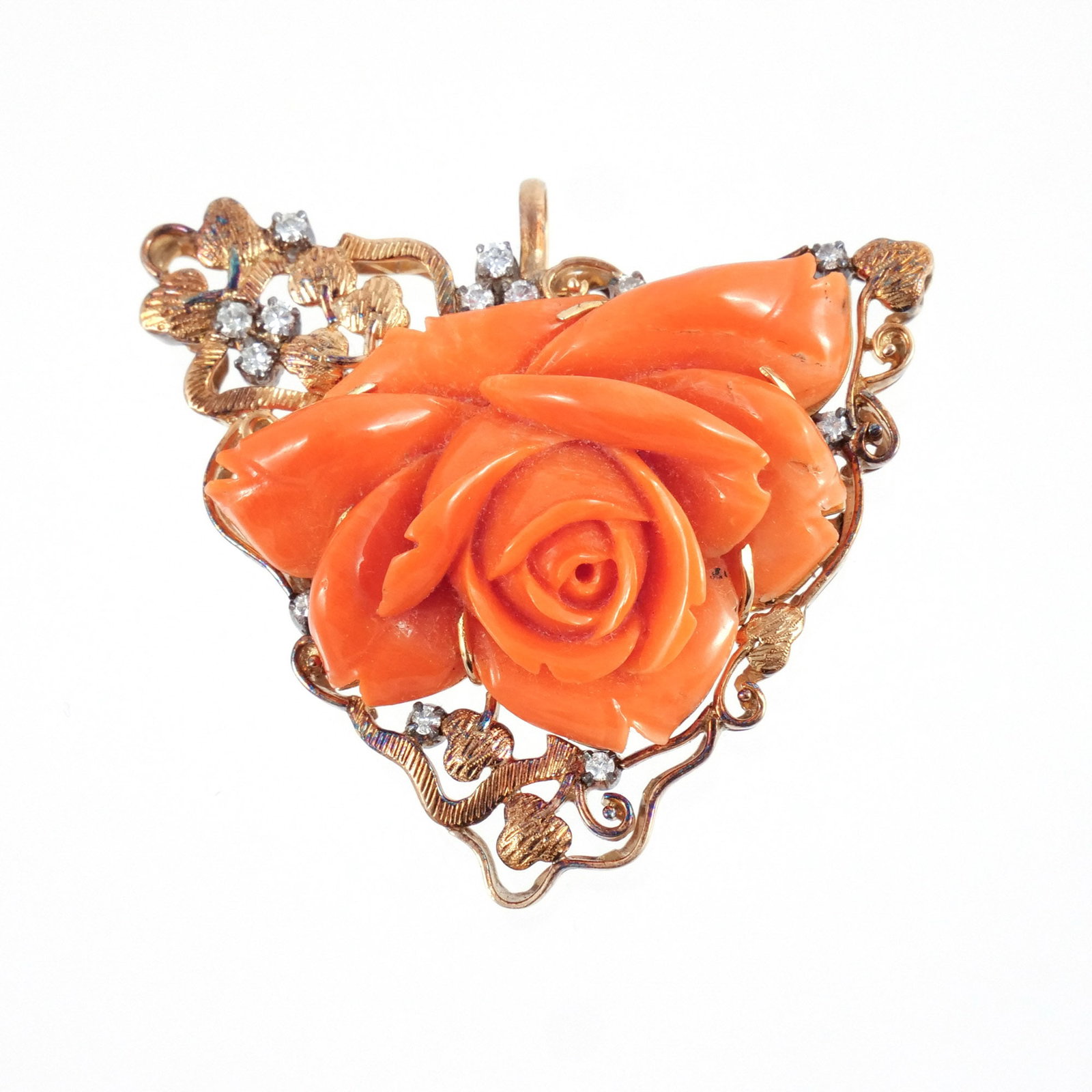 CORAL, DIAMOND, and 14K GOLD BROOCH: Coral of flowerhead shape on a foliate ground with melee diamonds, mounted as a pendant, unmarked but tests as 14k, 23 g total weight h. 1-3/4 w. 2 in. Provenance: Descended through the family of the 