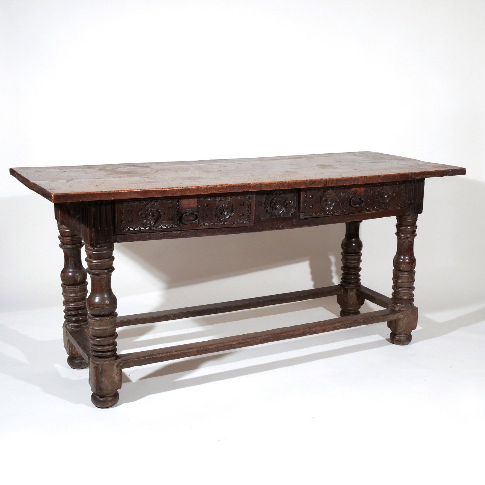 EARLY ENGLISH WALNUT / OAK REFECTORY TABLE: 17th century and later, having over hanging top, over two carved drawers, resting on heavy turned legs, attached by box stretcher, the whole resting on bun feet h. 31-1/4 w. 67-3/4 d. 26-1/2 in. [In S