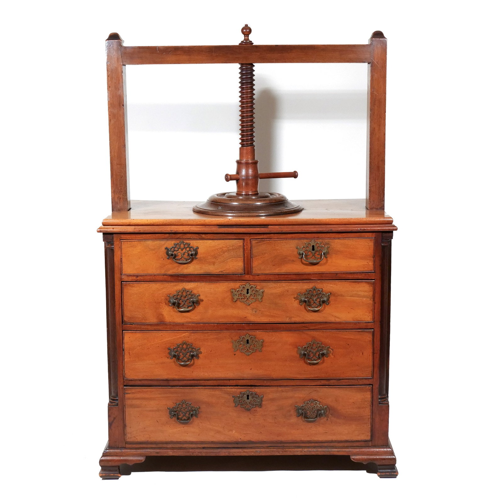 CHIPPENDALE-STYLE MAHOGANY LINEN PRESS CHEST: Mid 19th century, having a rectangular twisting press mechanism above two short drawers and three graduated long drawers, raised on ogee bracket feet h. 57-1/2 w. 38 d. 21 in. Provenance: The estate o