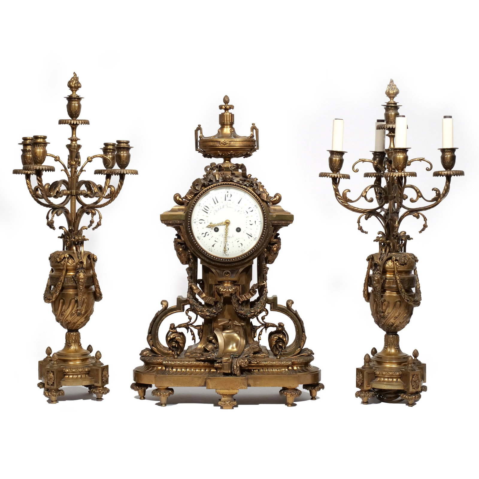 (3pc) MITCHELL VANCE & CO. ORMOLU CLOCK GARNITURE: New York, early 20th century, in the Louis XVI style, consisting of a clock and two five-light urn-form candelabra, interior clock stamped with serial number and maker's mark h. 25-1/2 w. 16 d. 8-1/2