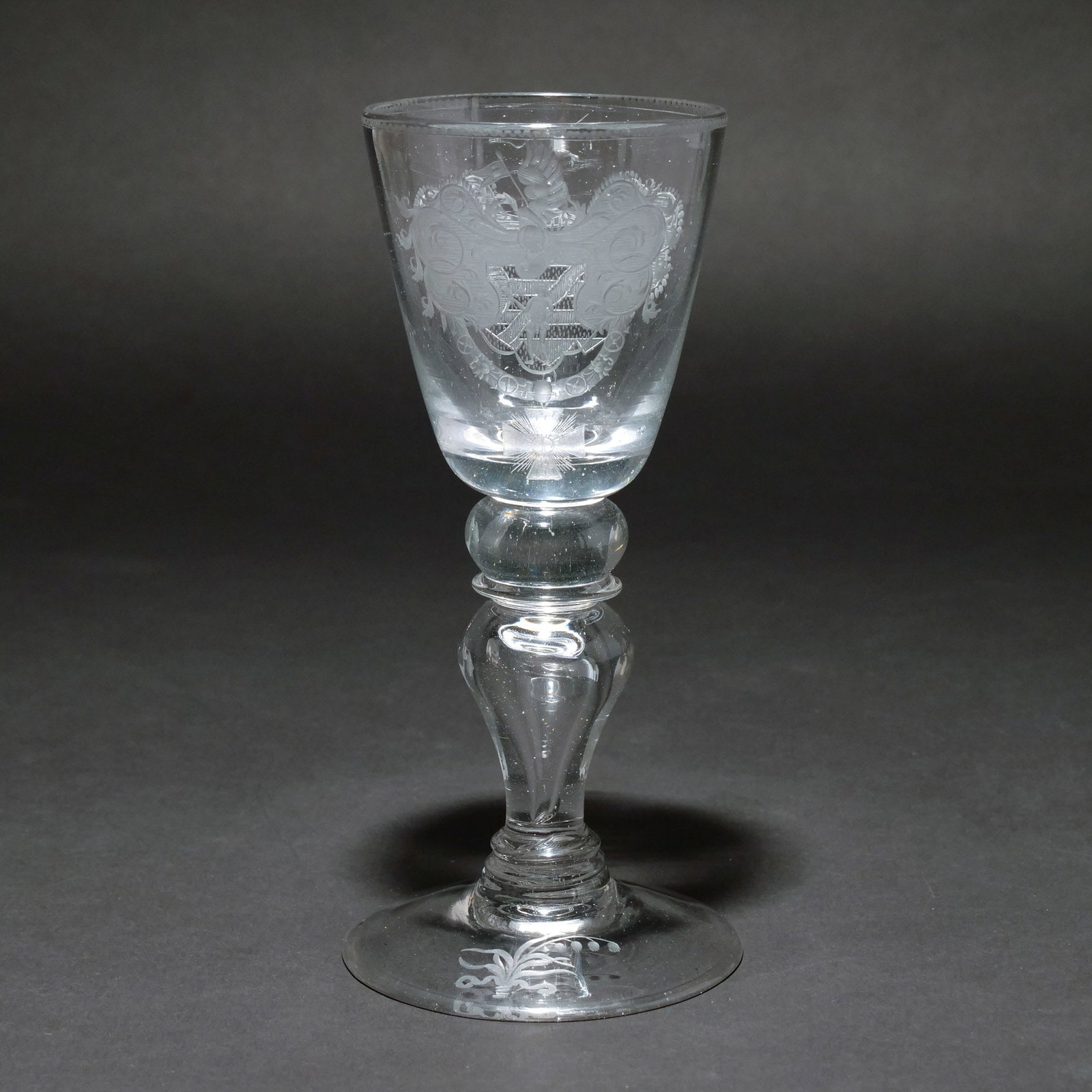 'WAPPENPOKAL' COAT OF ARMS GOBLET: Bohemia, 18th century, colorless glass, polished, cut, cup with a coat of arms with unicorn and a coat of arms with knight, jester, chain, and medal, foot with Lilies of the Valley h. 8-3/8 in. Proven