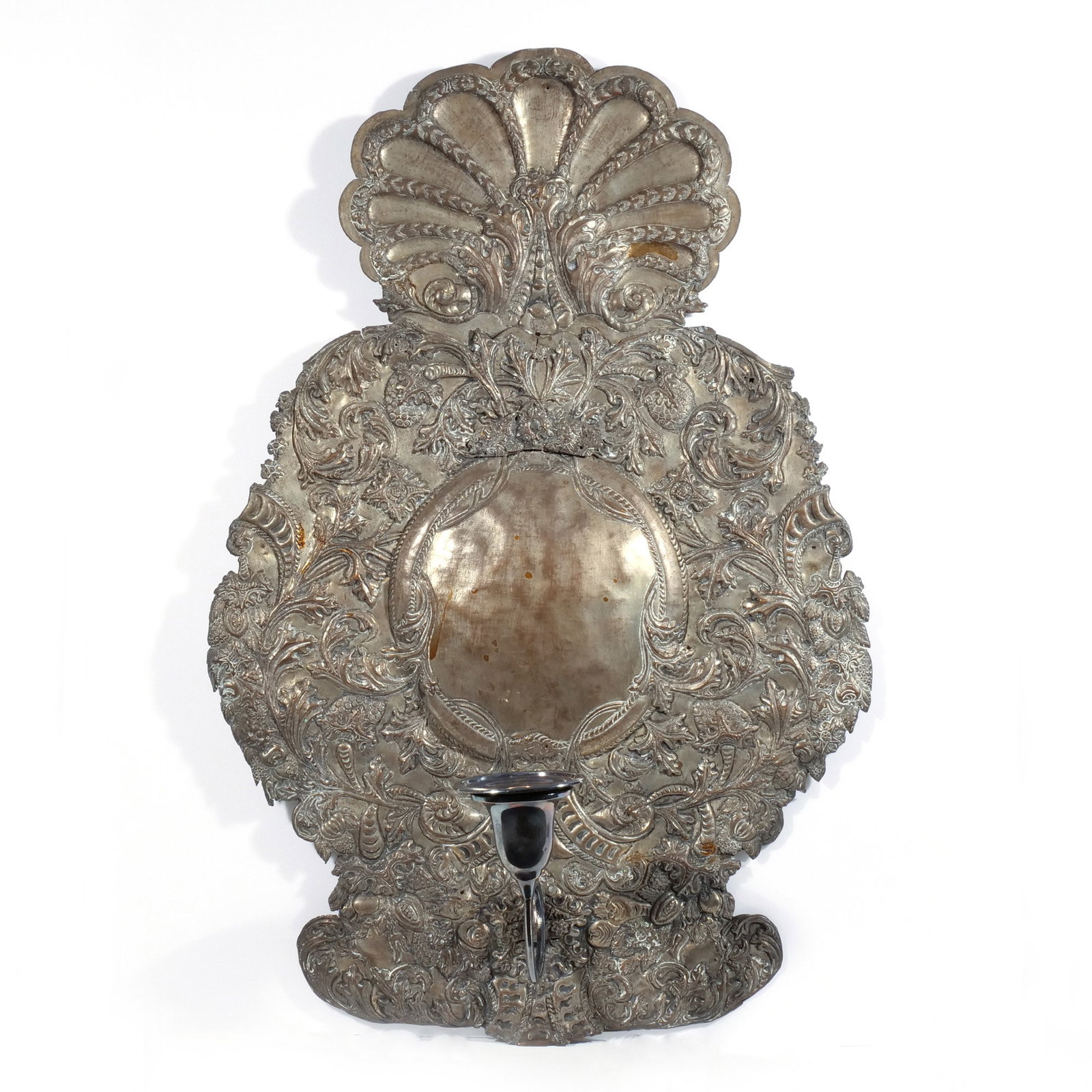 BAROQUE SILVERED COPPER 'WANDBLAKER' SCONCE: Bavaria, 18th century, of cartouche shape, crested by a scallop shell and with scrolling foliate designs in repousse, with a single replaced candle arm h. 25 w. 17 in. Provenance: Purchased by the con