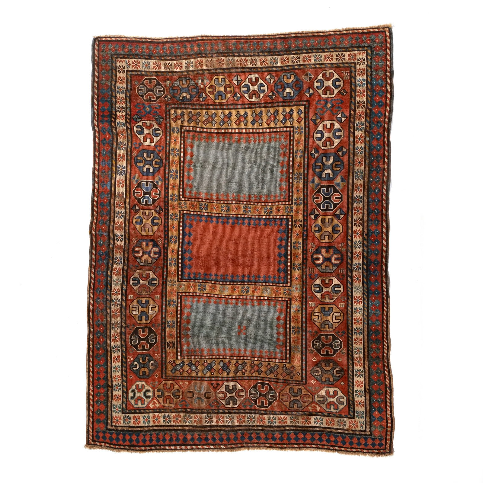KAZAK RUG: Late 19th century, with three rectangular color-field reserves alternating in red and light blue surrounded by red borders with octagonal guls h. 6 ft. 6 in. w. 4 ft. 10 in. Provenance: Private