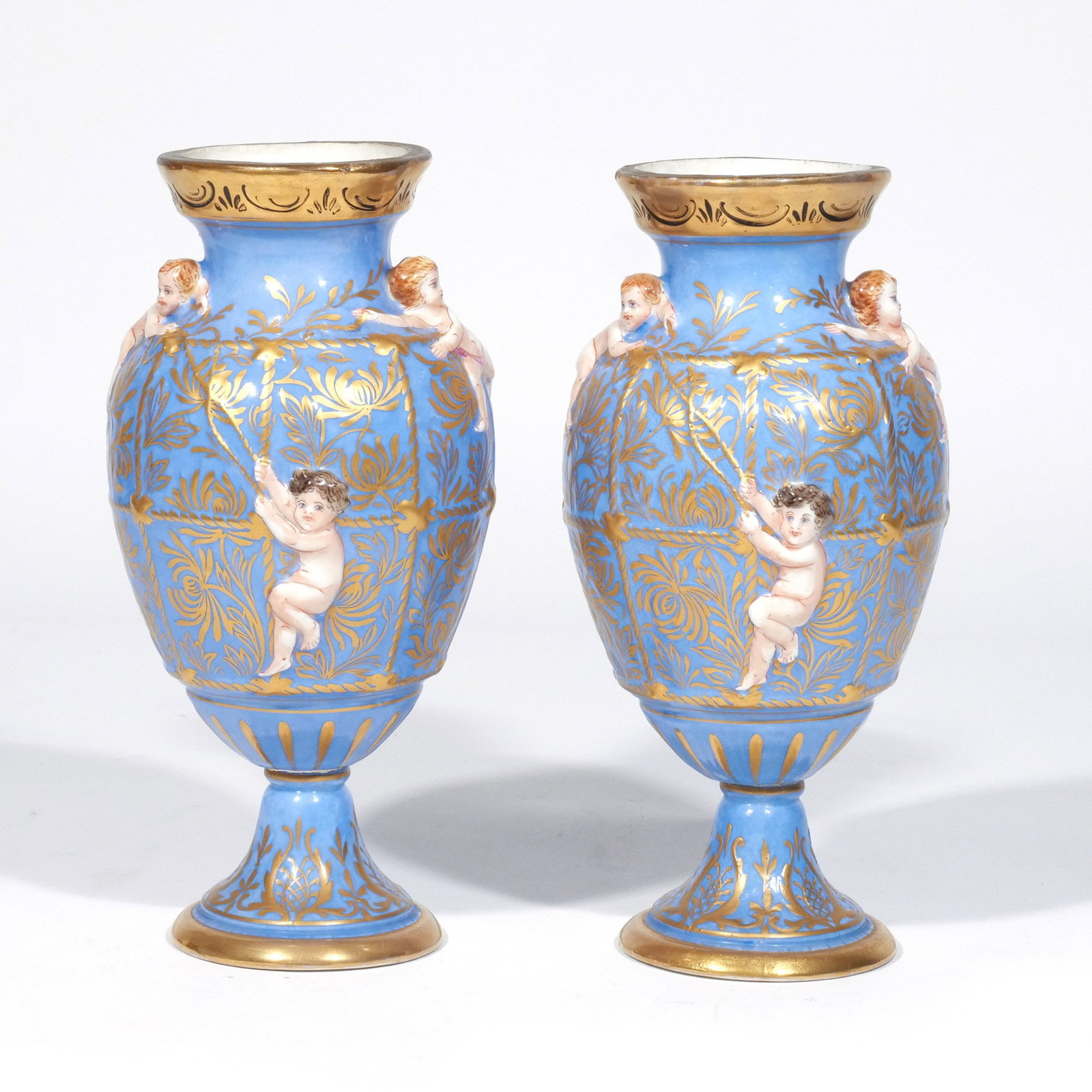 PAIR of 'SEVRES' TYPE PORCELAIN VASES: Late 19th / early 20th century, decorated with applied putti and raised rope decoration with gilt highlights on a light blue ground, pseudo Sevres marks and inscribed 'Made in France' h. 8-3/4 w.