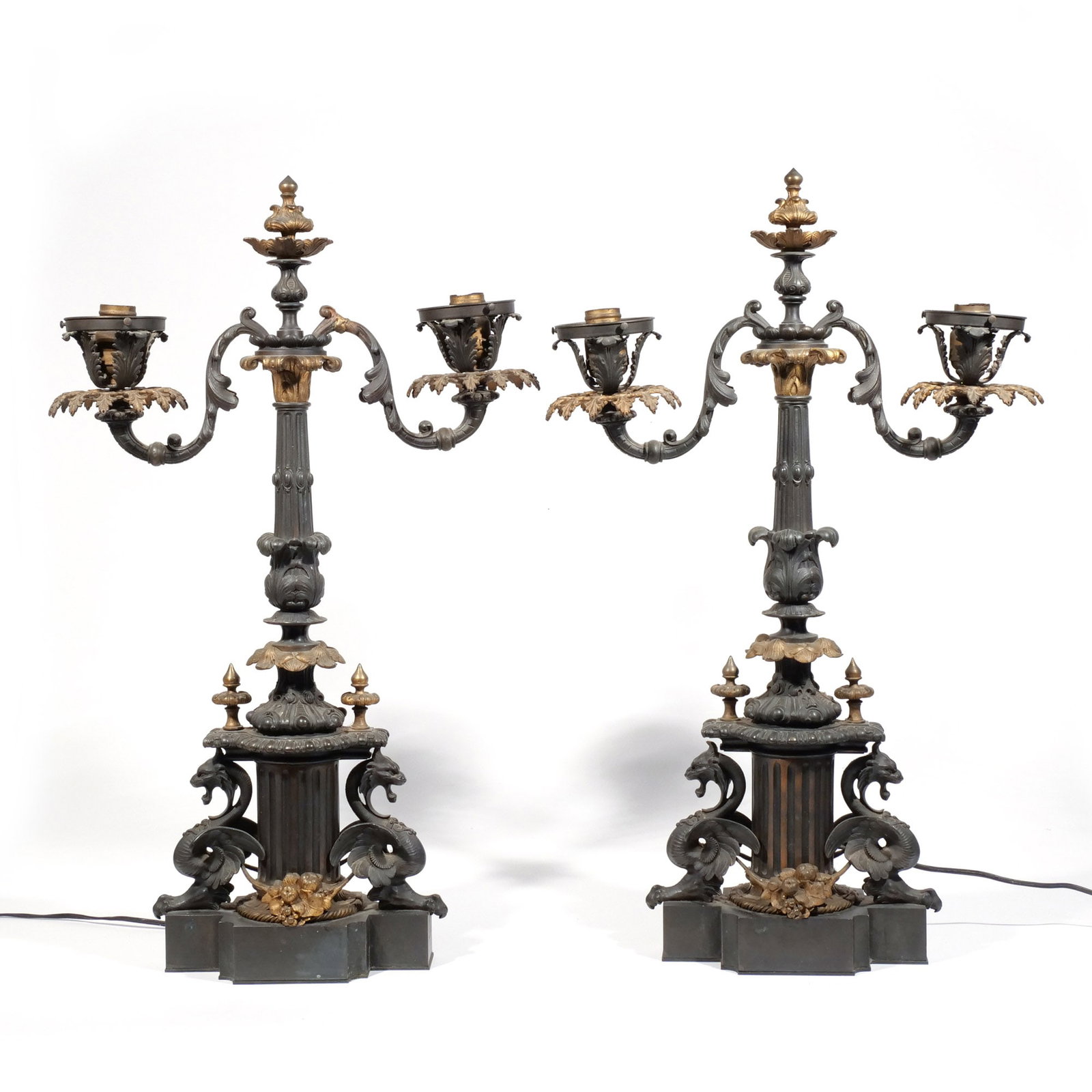 PAIR of CLASSICAL BRONZE TABLE LAMPS: Late 19th / early 20th century, with fluted columnar supports flanked by griffons, lacking the glass shades, electrified h. 28 w. 18 d. 5 in. Provenance: The estate of Richard and Jean M. Bergstresser