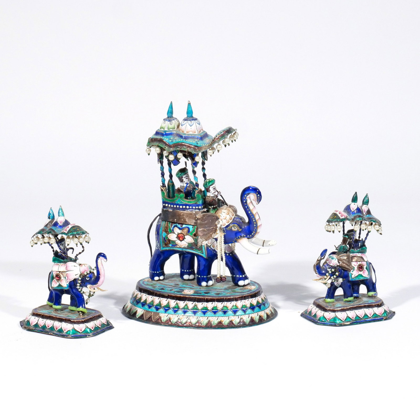 (3pc) INDIAN ENAMELED SILVER ELEPHANTS: 20th century, each shown with a howdah and riders on a platform base, including one large and a pair of smaller figures h. 7-3/4 w. 6 d. 4 in. (largest) Provenance: Descent through the consignor's
