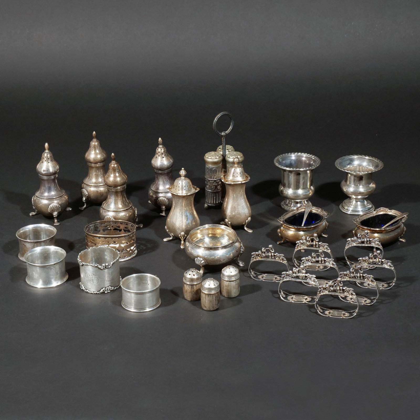 (28pc) STERLING SILVER SALT SHAKERS AND OTHER: Including a set of 4 matching sterling salts, a pair of English sterling silver salts with four feet, a pair of Tiffany & Co. sterling open salts with cobalt liners and non-matching salt spoons, 1 Con