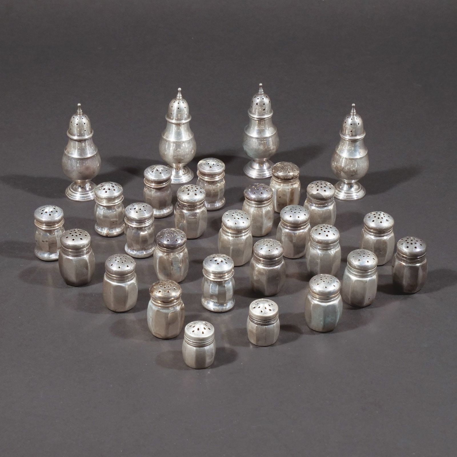 (28pc) STERLING SILVER SALT & PEPPER SHAKERS: Including a set of 4 of footed baluster shape, the remainder of low form with screw tops; 7 ozt total weight h. 3-1/4 in. (tallest) Provenance: Descent through a prominent Greenwich, CT doctor's estat