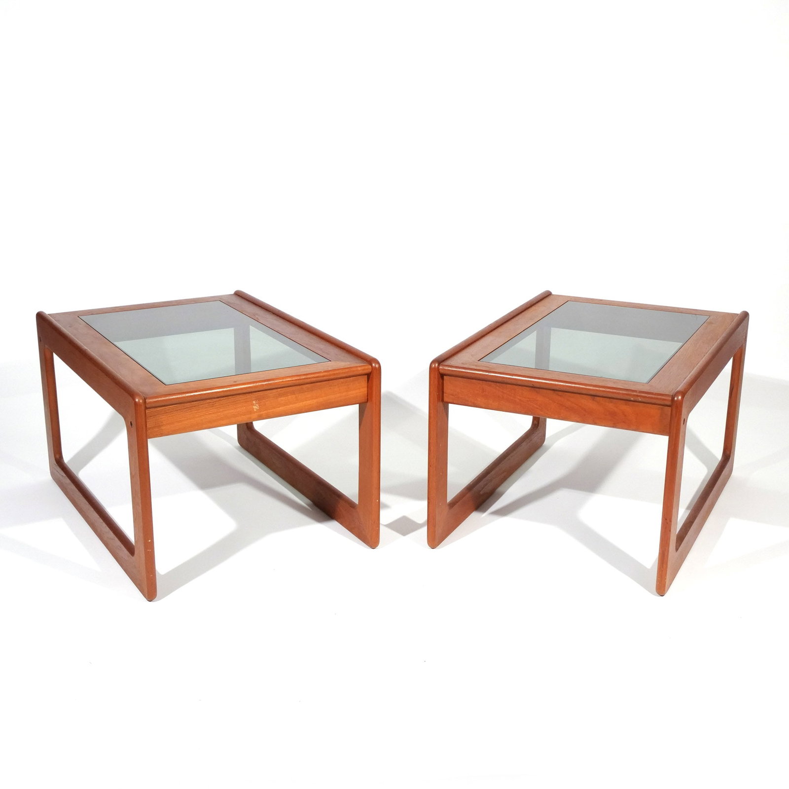 PAIR of DANISH MID-CENTURY TEAK END TABLES: By Komfort, with glass tops h. 16-1/2 w. 29 d. 20-1/2 in. [In Situ Item] This item will not be on display in our saleroom during our preview period. If you wish to view it in-person please make a