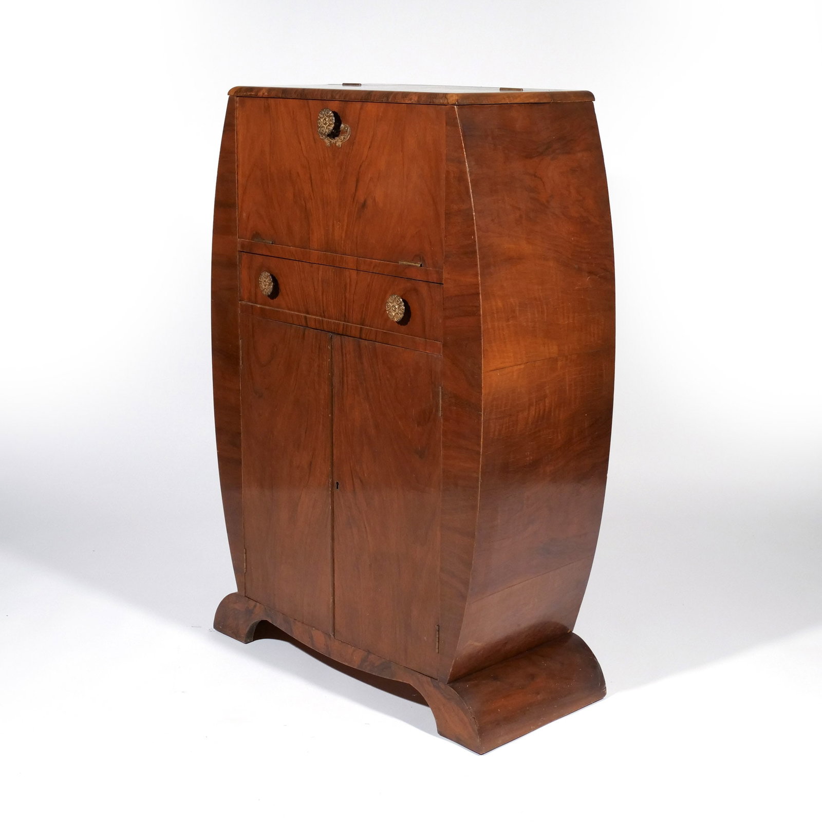 ART DECO ODEON-SHAPE WALNUT COCKTAIL CABINET: English, c. 1930, fitted with a mechanical top, above drawer and fitted double cupboard base h. 45 w. 29-1/2 d. 14 in. Provenance: Descent through a prominent Greenwich, CT doctor's estate [In Situ It