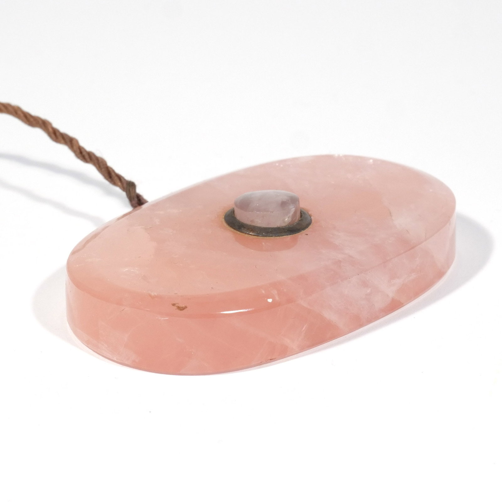 HARDSTONE SERVANT CALL BUTTON/BELL: Tourmaline or rose quartz: oval shape with faceted edges, metal button surround, original cord attached h. 1/2 w. 4-5/8 d. 2-1/8 in. Provenance: The estate of Richard and Jean M. Bergstresser, owner o