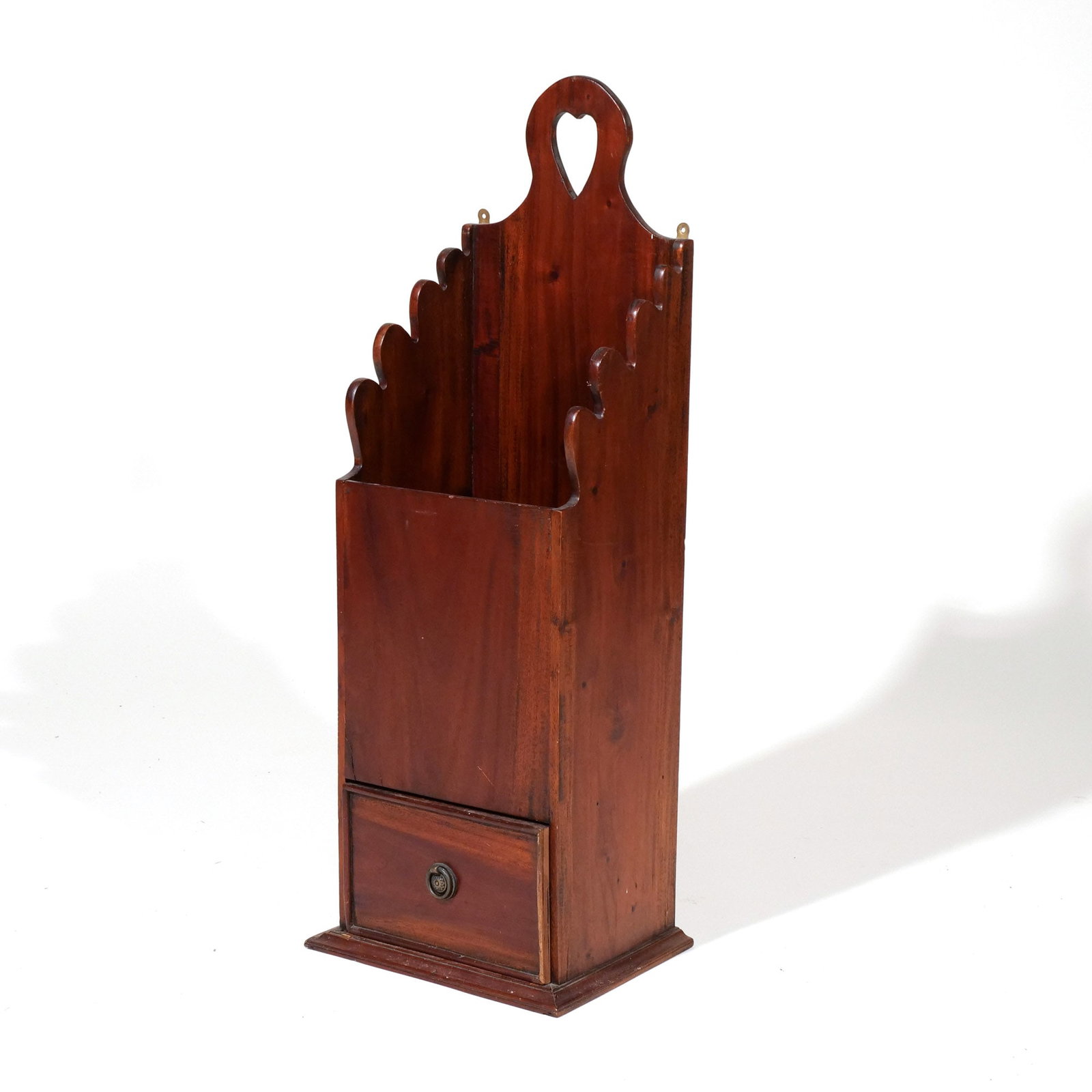 AMERICAN MAHOGANY OVERSIZE CANDLEBOX: 19th century, backboard crested by cut-out heart motif, graduated scalloped stiles, over lower drawer h. 31-1/2 w. 11-1/2 d. 8-3/4 in. Provenance: Private collection, Bernardsville, NJ