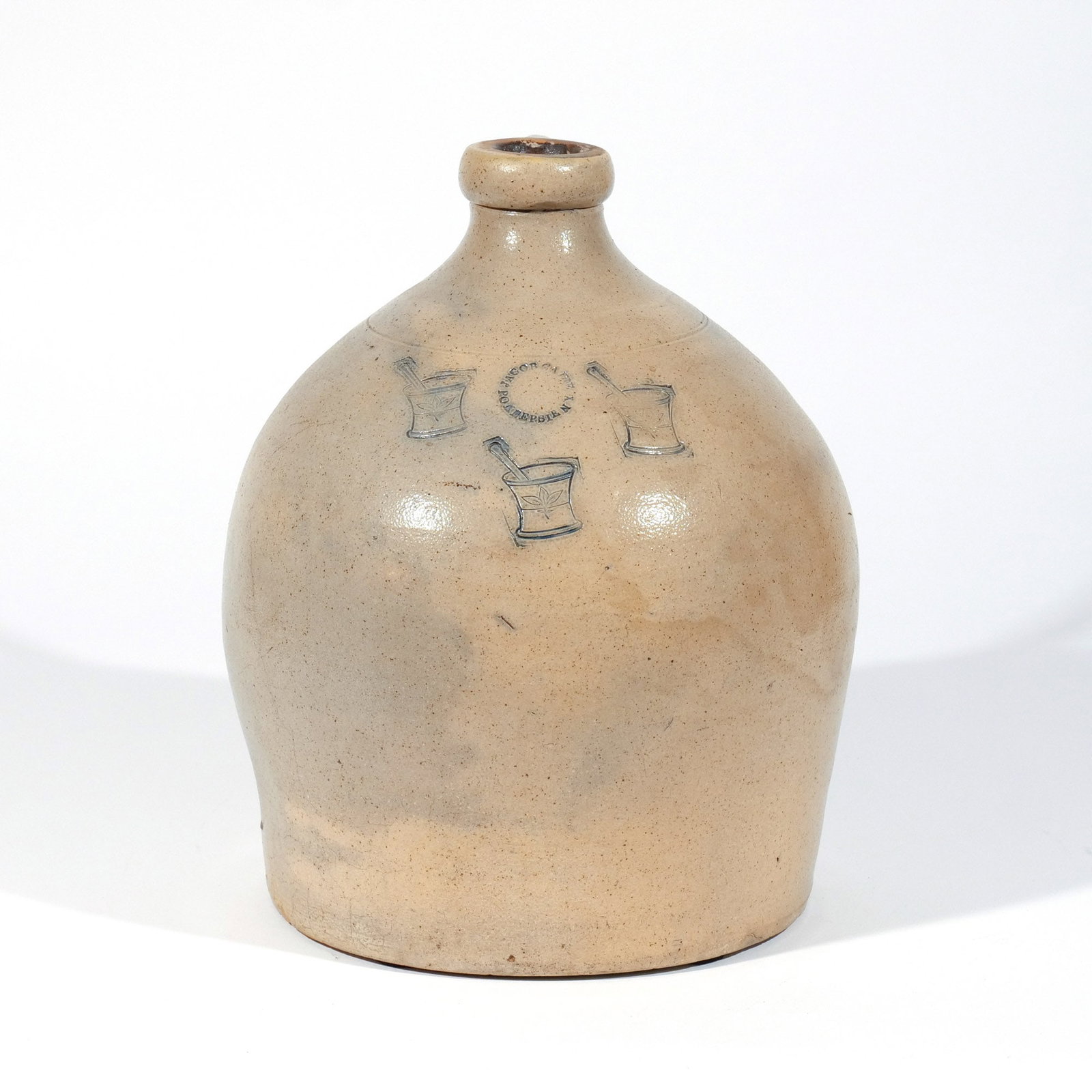 JACOB CAIRE STONEWARE JUG with MORTAR / PESTLE: Poughkeepsie, NY, circa 1849-1852, with unusual stamped decoration of three mortars and pestles, stamped circular mark 'JACOB CAIRE / POKEEPSIE N.Y.' h. 14 w. 13 in. Provenance: Private collection, Be
