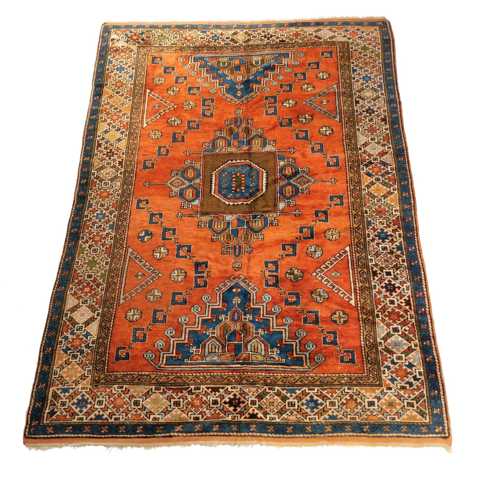 CAUCASIAN RUG: Mid 20th century, with a stepped medallion on an orange field h. 9 ft. 8 in. w. 6 ft. 5 in. Provenance: Descent through the consignor's family