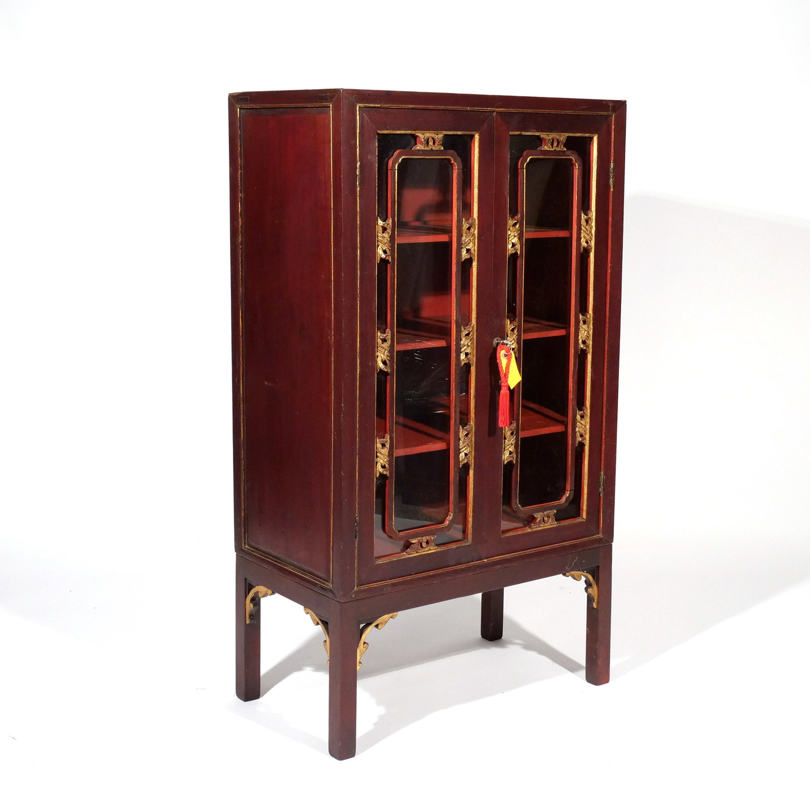 CHINESE EXPORT LACQUERED DISPLAY CABINET: 19th century, having double glazed doors, in red lacquer with gilt highlights h. 44-1/2 w. 25-1/4 d. 14 in. Provenance: Descent through a prominent Greenwich, CT doctor's estate [In Situ Item] This