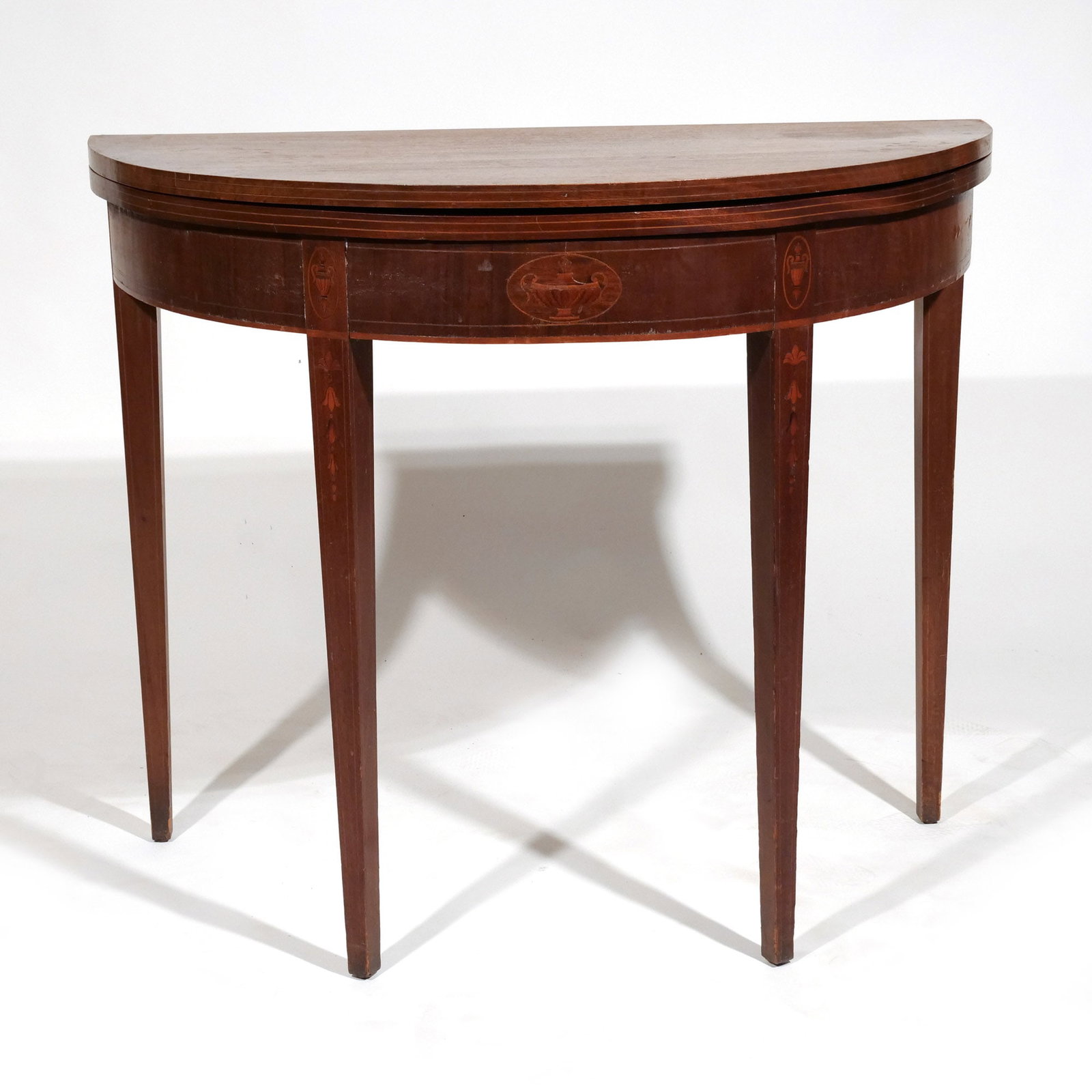 FEDERAL INLAID MAHOGANY BOWED GAMESTABLE: Early 19th century, having urn and bell flowering inlay h. 30 w. 35-1/2 d. 17-1/2 in. Provenance: Descent through a prominent Greenwich, CT family [In Situ Item] This item will not be on display in
