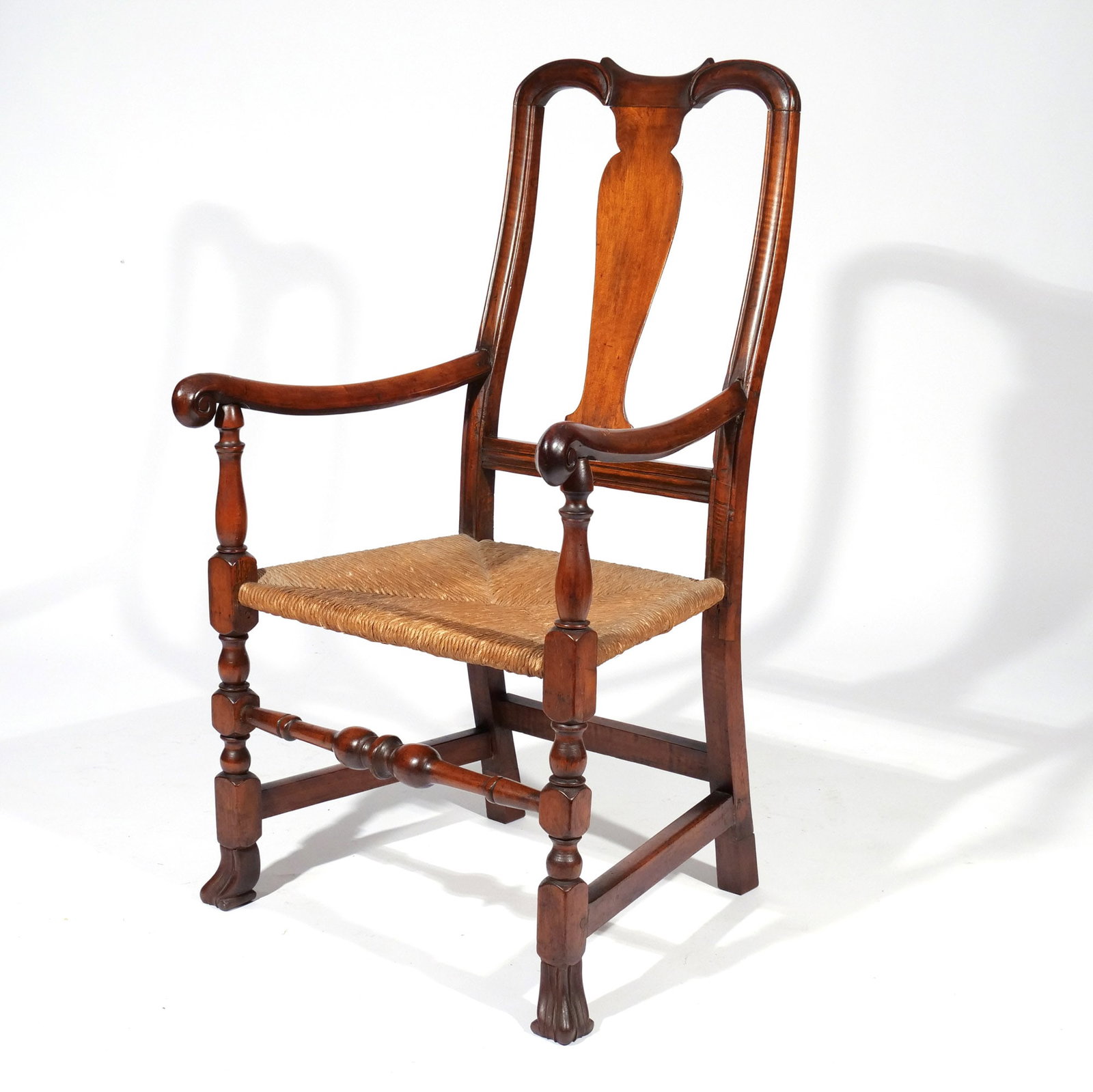 WILLIAM & MARY NEW ENGLAND MAPLE ARMCHAIR: c. 1730-50, having yoke crest above a vase-form splat, continuing to shaped arm rests terminating in scroll hand holds, rush trapezoidal seat, raised on block-and-bulbous turned legs joined by a
