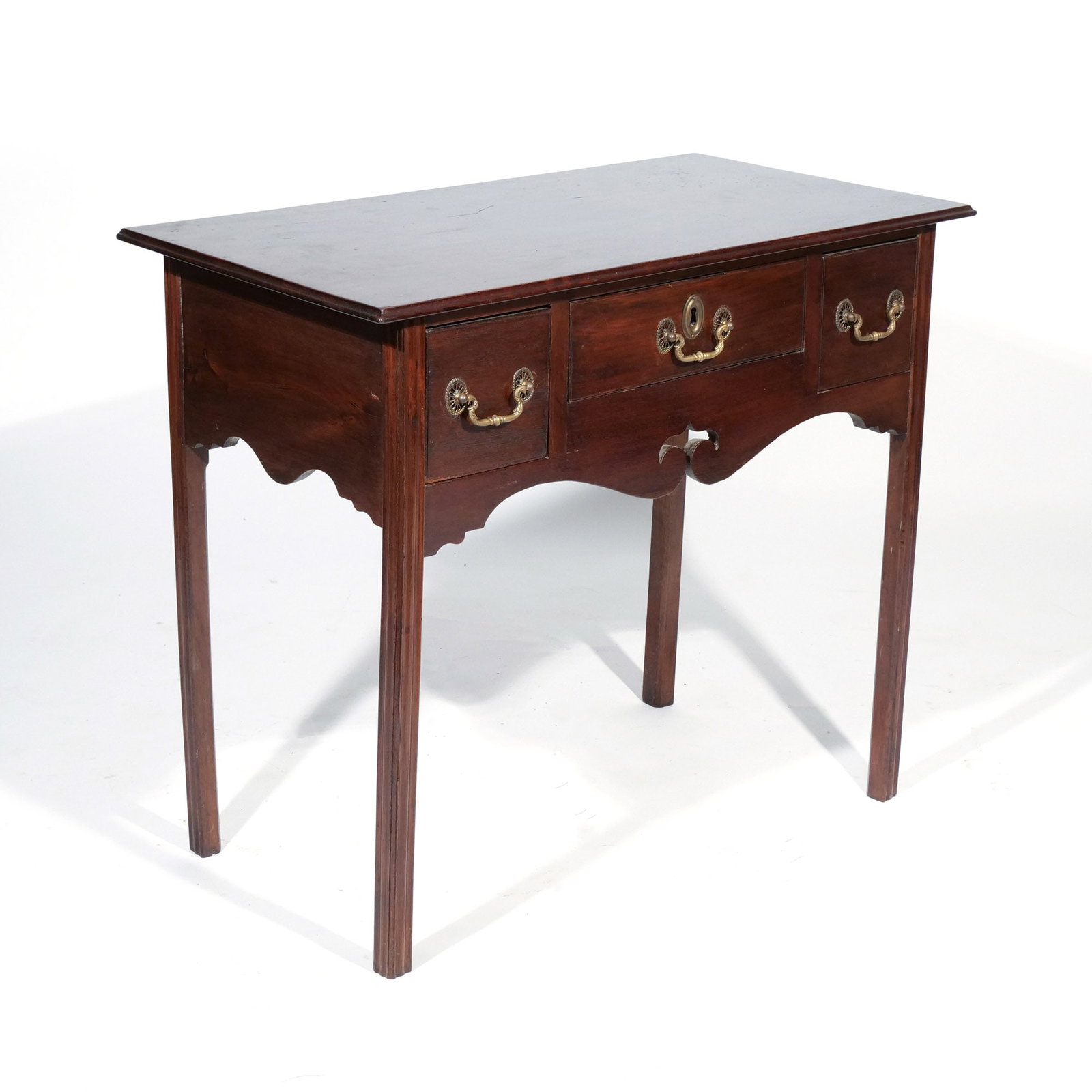 GEORGIAN MAHOGANY LOW BOY: With 3 drawers, having brass bail handles and a scalloped cut-out apron h. 28 w. 33 d. 17-1/2 in. Provenance: Landmark Hoyt Homestead, Pound Ridge, NY