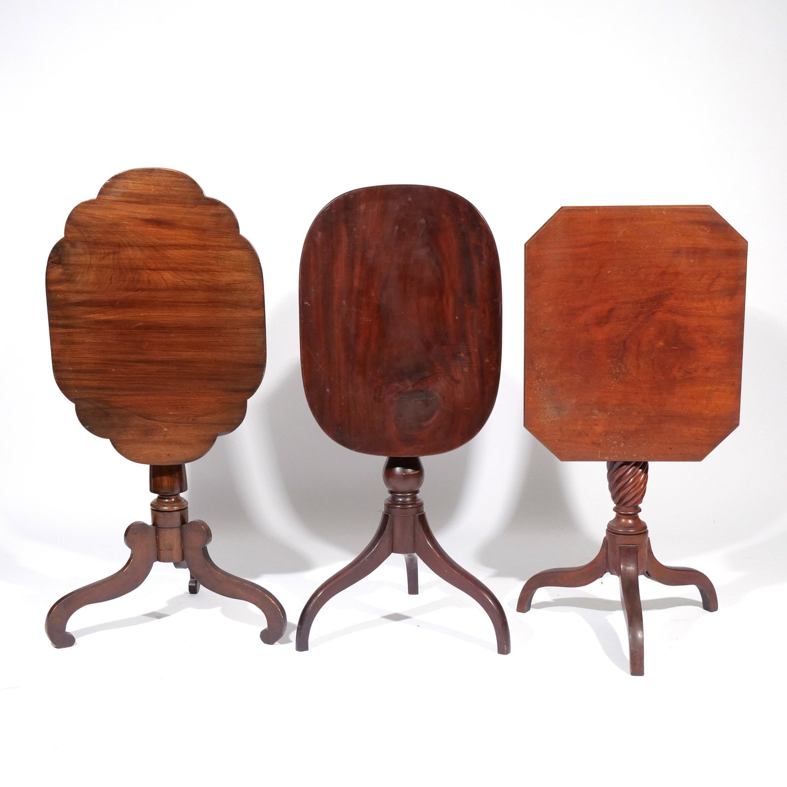 (3pc) ANTIQUE MAHOGANY TILT-TOP TABLES: 19th century, all with tripod bases, including one with a shaped top, one with a rounded rectangular top, and one with a rectangular top having canted corners h. 28 w. 26-1/2 d. 19 in. (largest)