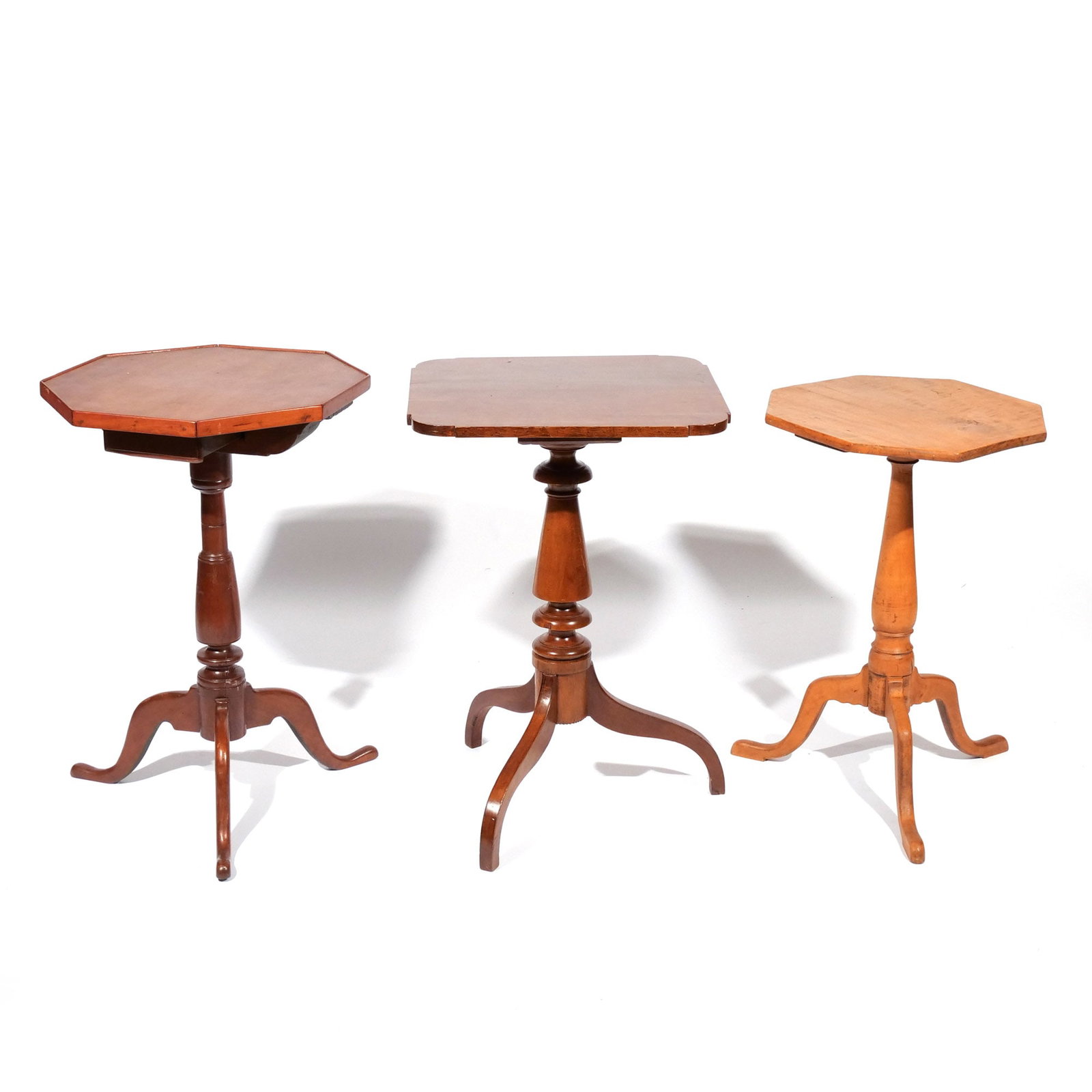 (3pc) AMERICAN CANDLESTANDS: 19th and 20th centuries, including one with an octagonal top and single drawer; one with a square top and shaped corners; and one in maple with an octagonal top h. 27 w. 19 d. 18 in. Provenance: