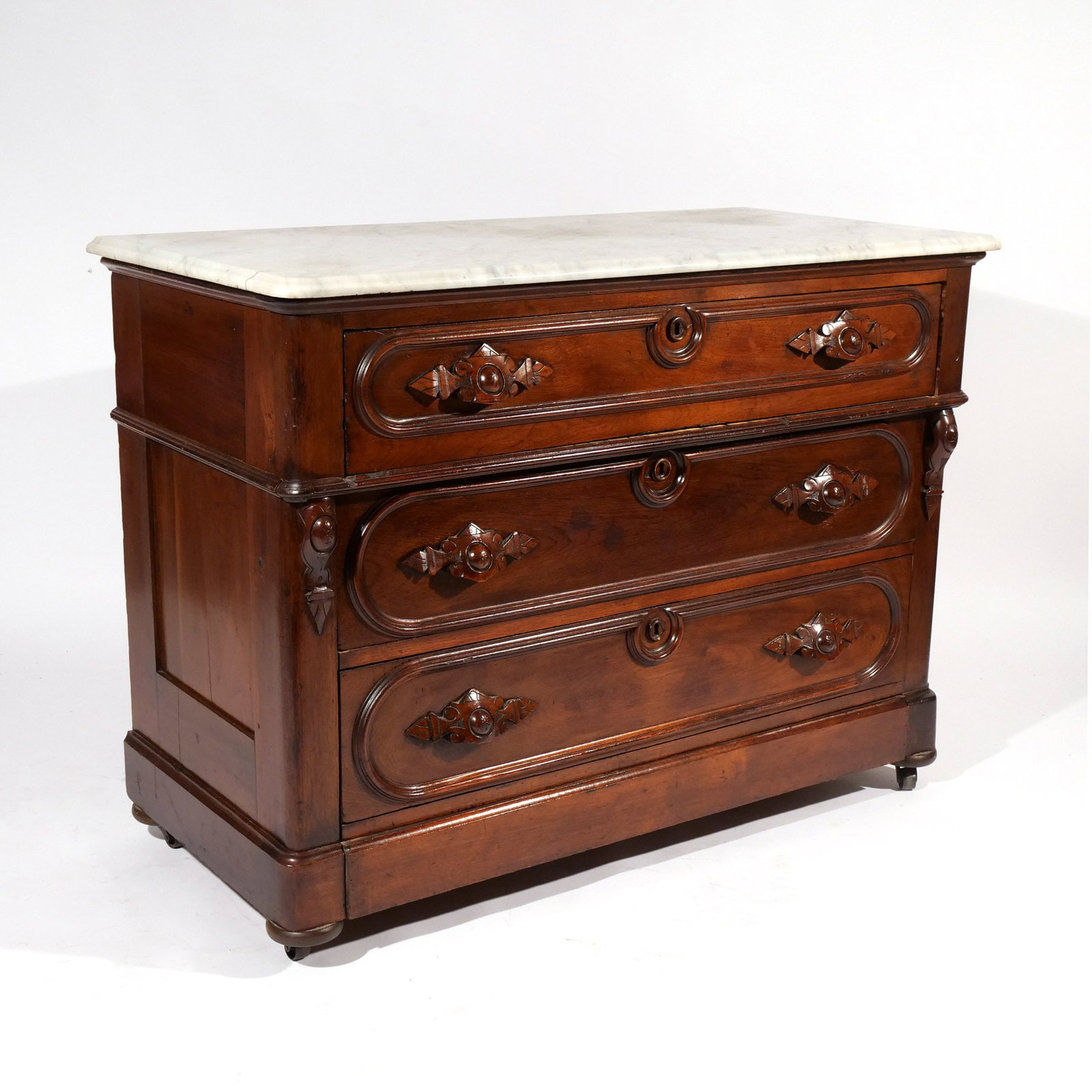 VICTORIAN WALNUT MARBLE TOP DRESSER: Having three full-width drawers with leaf shaped drawer pulls, mounted on casters h. 34 w. 45 d. 21 in. Provenance: Landmark Hoyt Homestead, Pound Ridge, NY [In Situ Item] This item will not be on