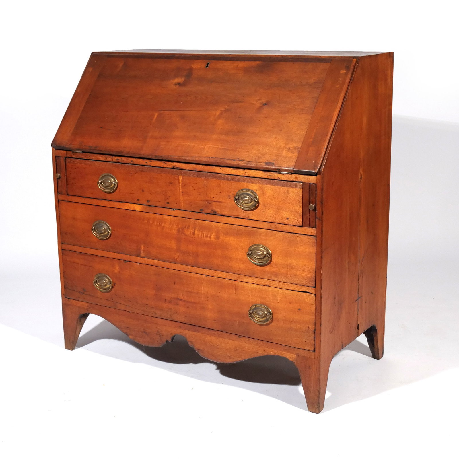 GEORGIAN CHERRY SLANT LID DESK: Fitted interior, over three full-width drawers, over scalloped apron, mounted on French feet h. 40-1/2 w. 40 d. 20 in. Provenance: Landmark Hoyt Homestead, Pound Ridge, NY [In Situ Item] This item