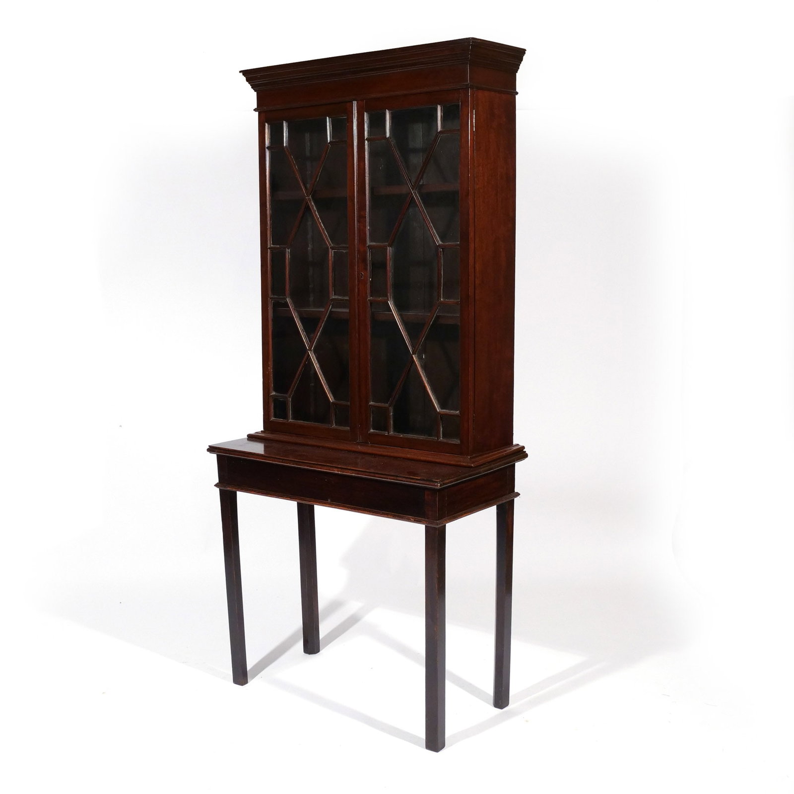SHERATON-STYLE MAHOGANY BOOKCASE: Early 20th century, with a two-door glazed upper case over a rectangular table with square legs h. 69 w. 32 d. 16 in. Provenance: Landmark Hoyt Homestead, Pound Ridge, NY [In Situ Item] This item