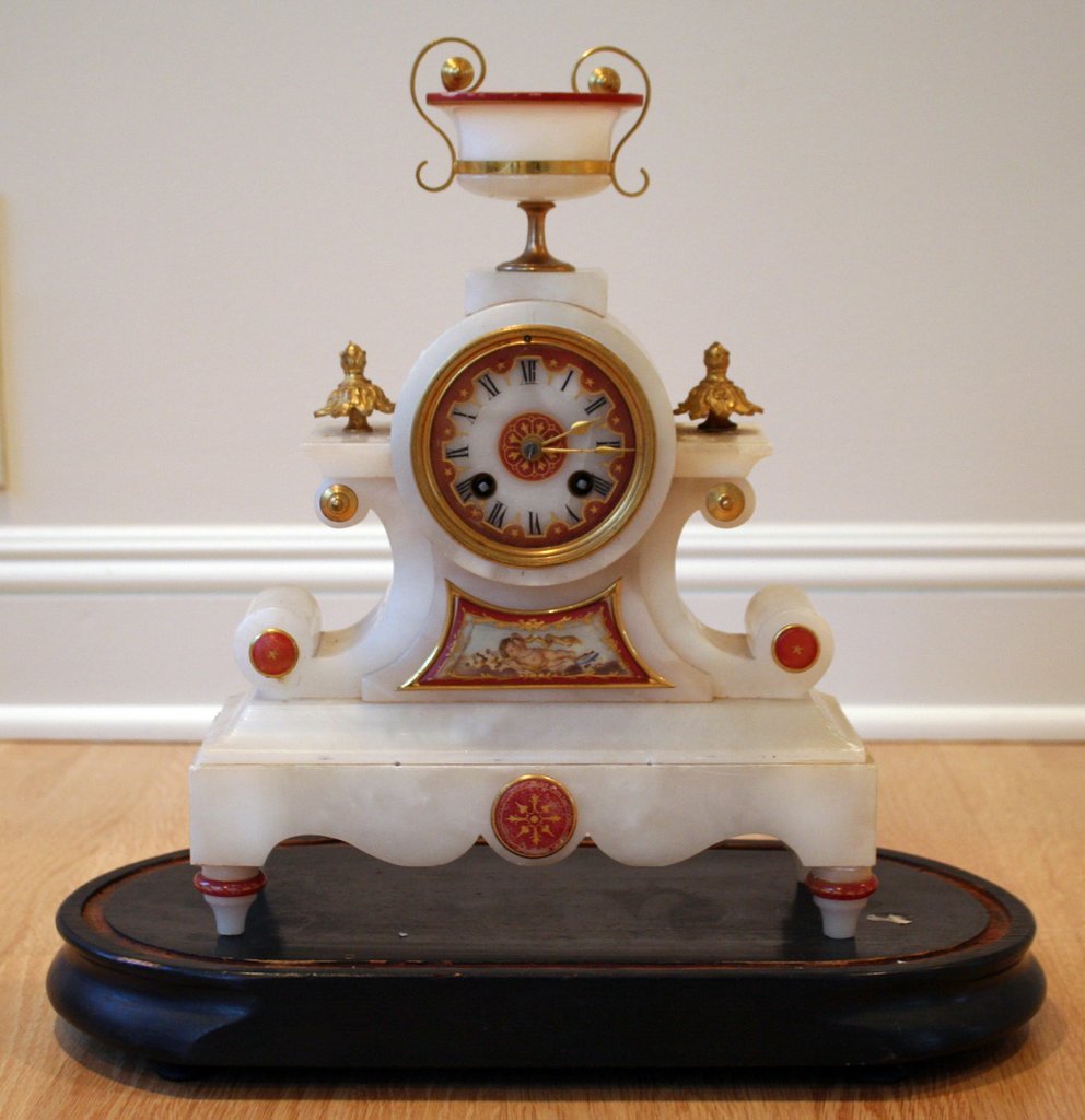 15A) JAPY FRÈRES VICTORIAN ALABASTER SHELF CLOCK: with applied mother of pearl floral decorations. H: 18" W: 16" D: 8" With a fitted glass dome and stand.