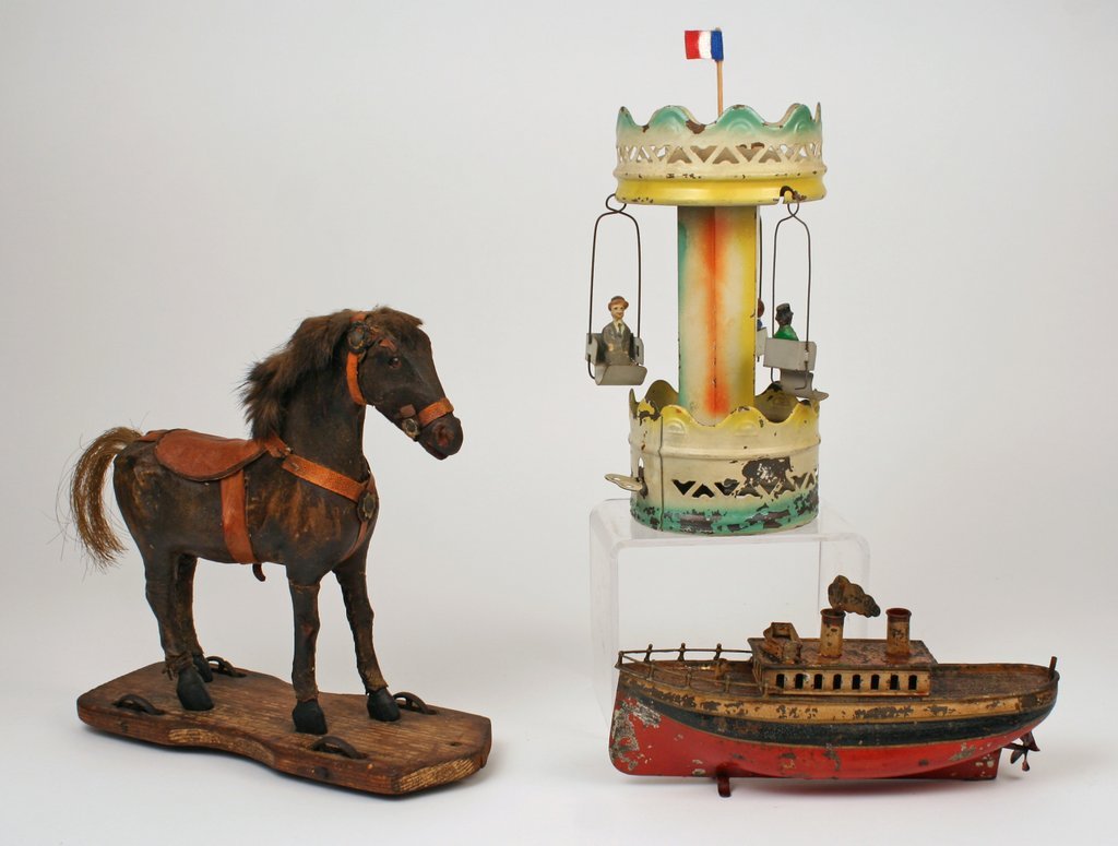 46) 3 PC. TOY LOT: French wind-up tin carousel,: H: 8 ¾" D: 4 ¼"; a windup metal tug boat, L: 8 ¾"; and a leather & horsehair pull-toy in the form of a horse, H: 9 ¾", base: L: 9 ¾", W: 3 ¾"