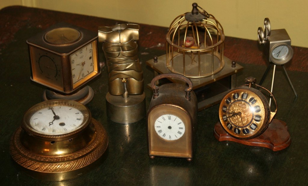 232) GROUP OF 5 DESK CLOCKS, one in the form of: a camera, plus a caged musical songbird.