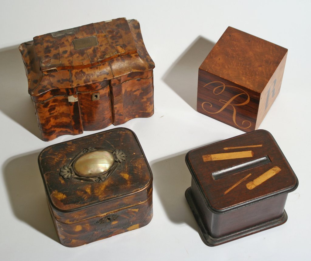 334) FOUR TABLE TOP ITEMS: one tortoise-shell tea caddy: damage, a cigarette box, wooden paper weight with initial "R", and a faux-tortoise box, height range: 4" - 5 ¾"