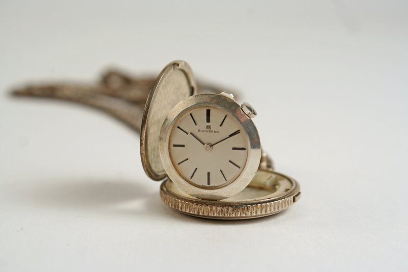 540Q) BOUCHERON WALKING LIBERTY HALF DOLLAR PENDANT: WATCH; flip out case, baton numerals, case dia. 1-3/4", face dia 3/4" w/ .925 chain, tot. wgt. 92 grams