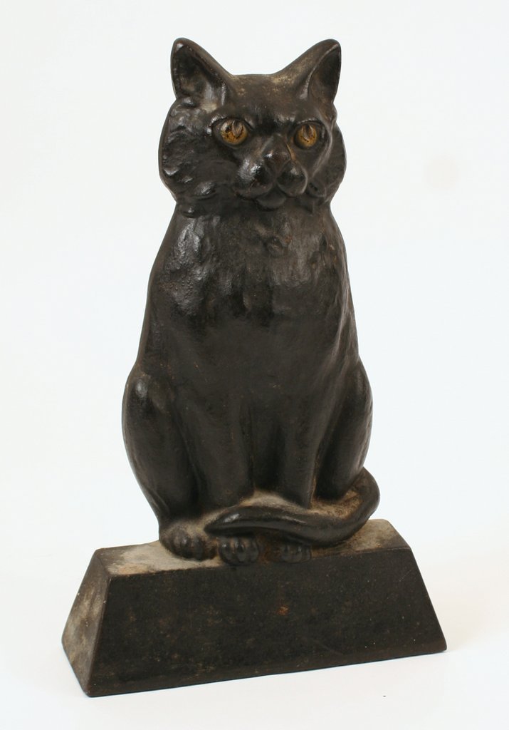 580) L. 19/E.20THC. BLACK CAT ON BASE CAST IRON: DOORSTOP TAIL CURLED AROUND BODY, W/YELLOW EYES, VERY HEAVY, H. 12 ½", L. 7 ½", D. 2 ¾"