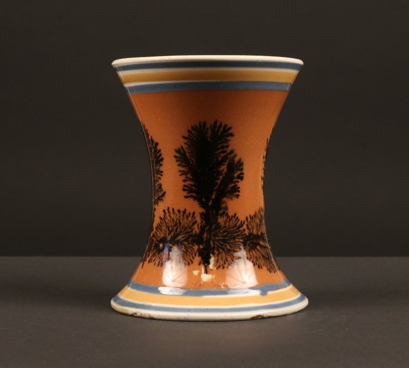 ENGLISH MOCHAWARE SPILL VASE,: early 19th Century, of waisted cylindrical form, the pearlware body slip-decorated with alternately vertical and horizontal dendritic 'trees' on an orange ground, h. 4 ½", Provenance: with Fiona & Bi