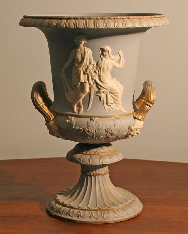 19th C. JASPERWARE CAMPANA FORM URN with: classical figures in cameo and gilt highlights, foot repaired, H: 14 ½" D: 11"