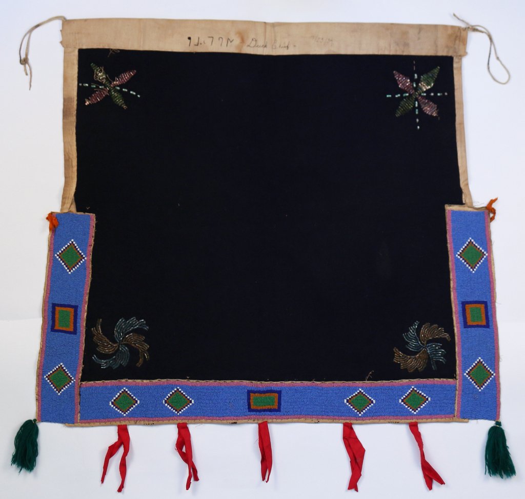 NATIVE AMERICAN BEADED DANCE APRON: circa 1930's, the midnight blue field with four beaded emblems in the corners surrounded on three sides with bands of beadwork in light blue, green, orange, white, pale purple, and dark blue, inscribe