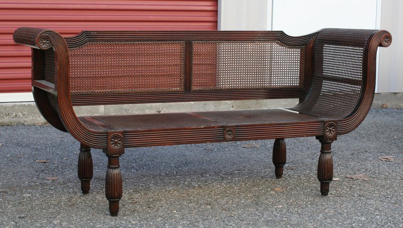 ART DECO REEDED MAHOGANY SETTEE: with scrolling arms and cane seat and backrest, h. 32" w. 70" d. 21", with break in cane at seat