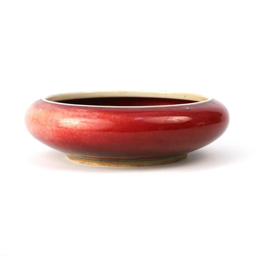 CHINESE GLAZED CERAMIC BRUSH WASHER: Qing Dynasty, of squat round form with a varying red glaze and green underglaze, d. 7 1/4", h. 2 1/4"; with a central crack (appears to be contained and original)