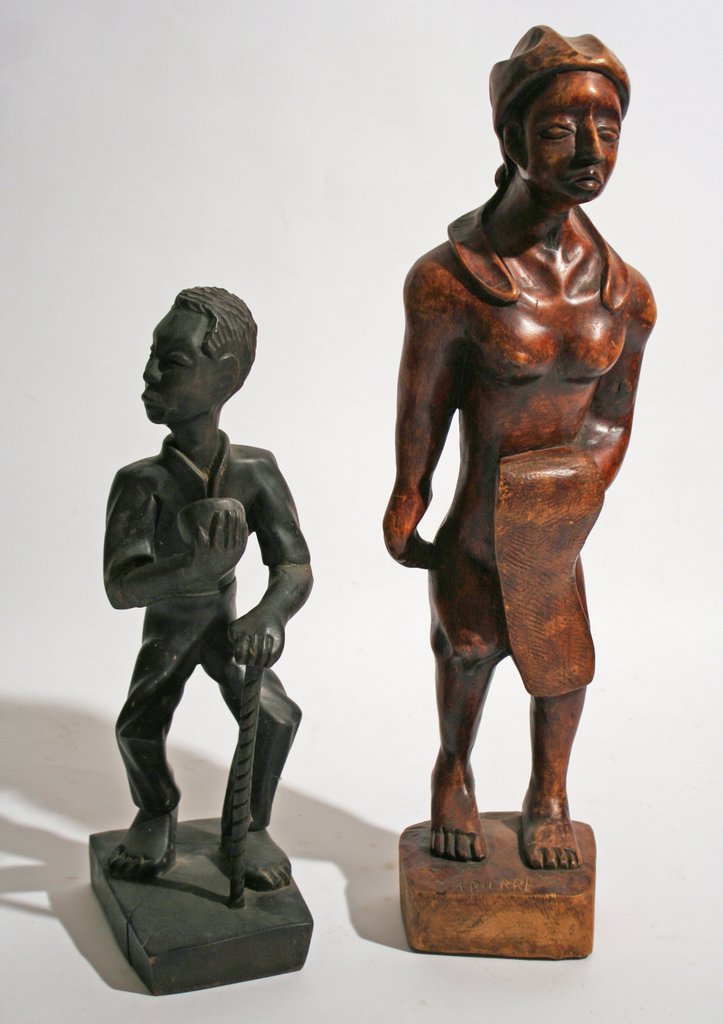 THREE NAÏVE FIGURAL WOOD CARVINGS,: one of a man with a walking stick, H: 14 ¾", signed "C. Simeon" on bottom; the other of an African-American woman, H: 20", signed "A. Pierre"; and one whimsical figure of a pacific islander boy with 