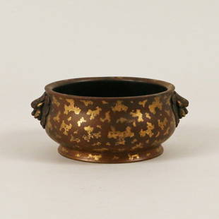 CHINESE GILT-SPLASHED BRONZE CENSER: with a slightly splayed lip and constricted neck flanked by chased lion's heads on either side, with six-character mark on bottom, h. 2 1/2" d. 5"