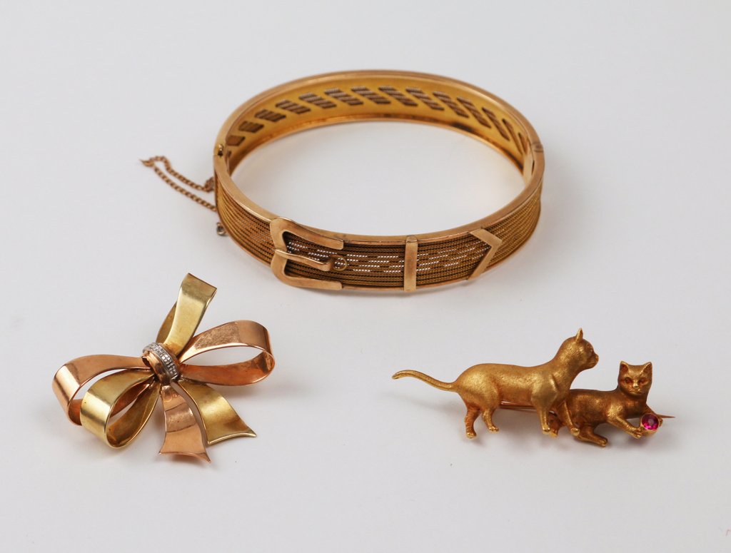 (3pc) LADY'S GOLD JEWELRY LOT:: including a 14kyg belt-form hard bracelet, with a few minor dings; a 14kyg cat-form pin; and a 14k green and pink gold bow form pin; tot. wgt. 34.8 gms