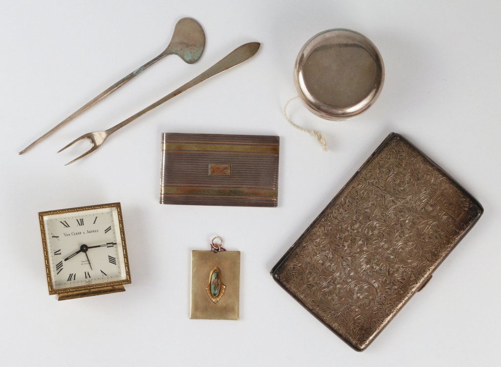 (7pc) DESIGNER ACCESSORIES: including a Van Cleef & Arpels travel clock, appears to be working, h. 2 1/4"; a Cartier silver & 14ky & pink gold note pad, l. 3"; a Tiffany & Co. sterling silver yo-yo; an Arts & Crafts-style locket