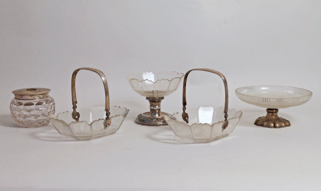 FIVE CUT-GLASS AND SILVER-MOUNTED TABLE PIECES: Including a compote with a scalloped foot, h. 3" d. 7"; a compote with paneled sides, h. 4 1/2"; a hair receiver, h. 3 1/4"; and two baskets with bail handles, h. 6" w. 7 1/2"