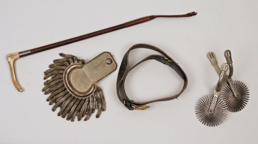 FIVE MEN'S ACCESSORIES: Including a pair of Southwestern pewter spurs; a late 19th/early 20th Century American eagle brass belt buckle; a riding crop with a bone handle; and a single epaulet having a button with an eagle mar