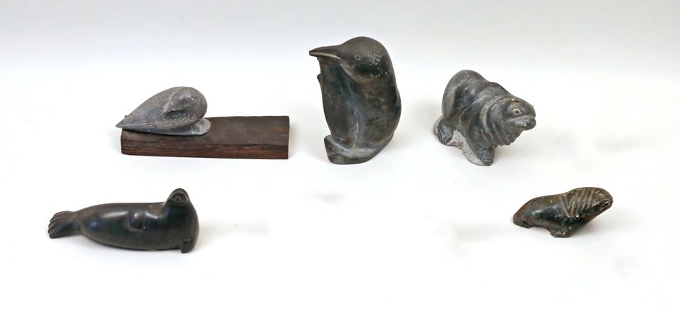 5 SOAPSTONE INUIT CARVINGS: Including a penguin with a fish, h. 7 3/4"; a reclining seal by Lizzie Amagoalik of Sanikiluaq, 8" long; an upright sea lion, h. 4 1/2"; a walrus, 5" long; and a figure of a dove on a wooden stand, 10
