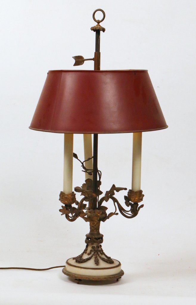 LOUIS XVI-STYLE THREE LIGHT TABLE LAMP: with a round marble base, ormolu mounts, and a red tole shade, h. 26 1/2"
