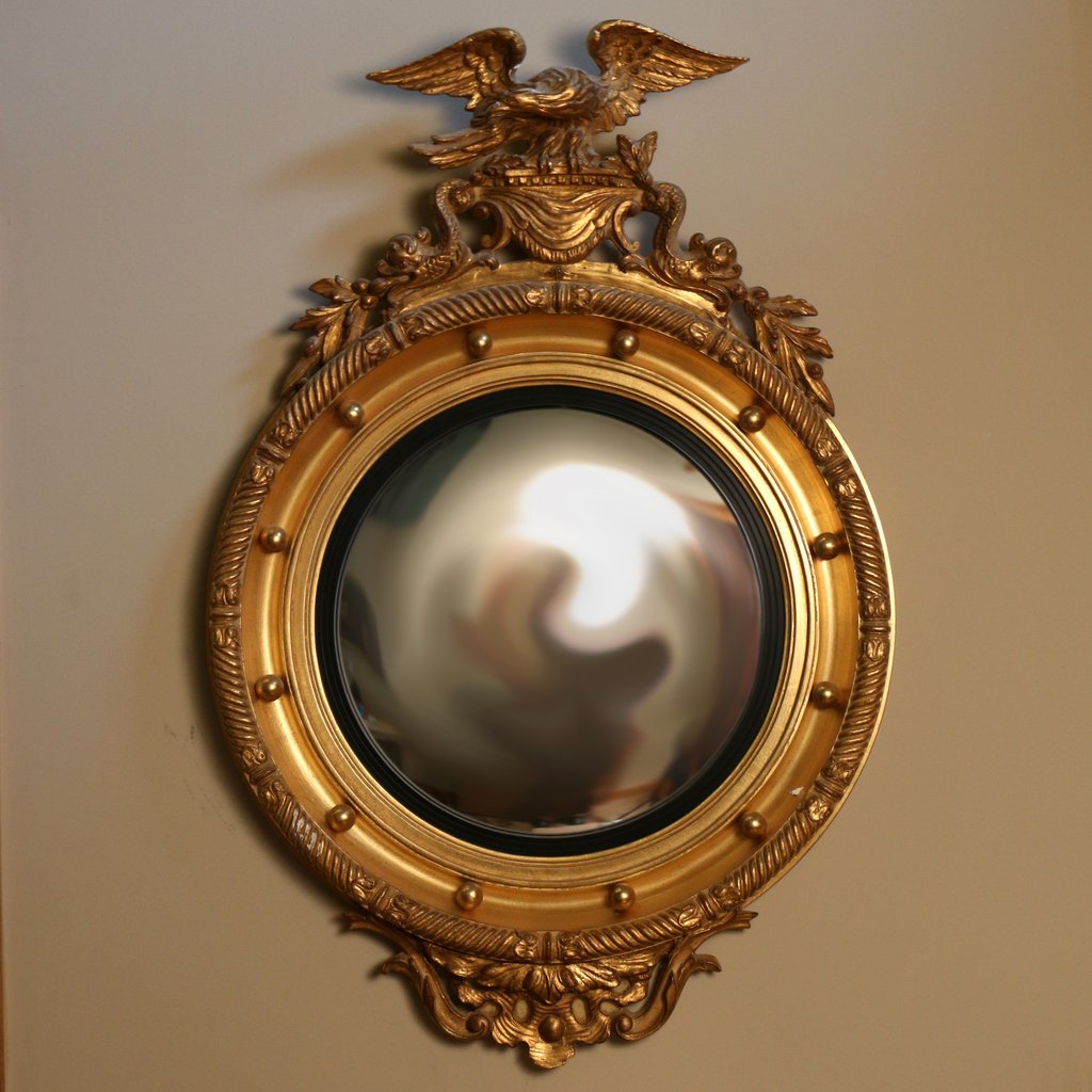 REGENCY STYLE GILT CARVED CONVEX MIRROR: 20th Century, crested by an Eagle and dolphins, h. 38" w. 26"